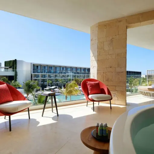 Ambassador Suite terrace with red armchairs and a whirlpool tub at TRS Coral Hotel, Cancun