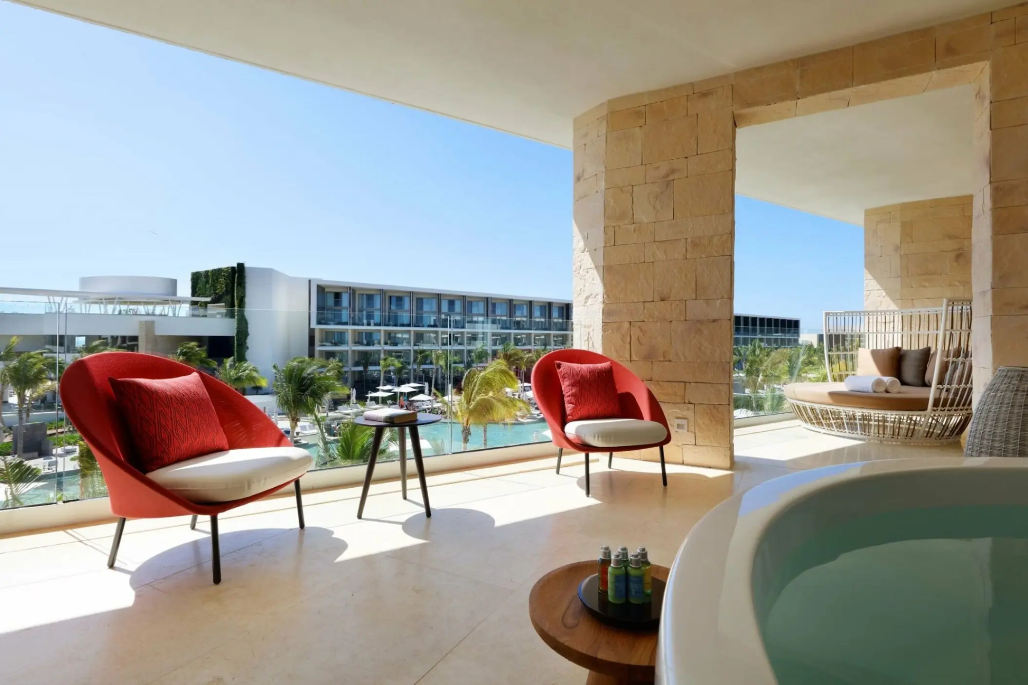 Ambassador Suite terrace with red armchairs and a whirlpool tub at TRS Coral Hotel, Cancun