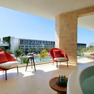 Ambassador Suite terrace with red armchairs and a whirlpool tub at TRS Coral Hotel, Cancun