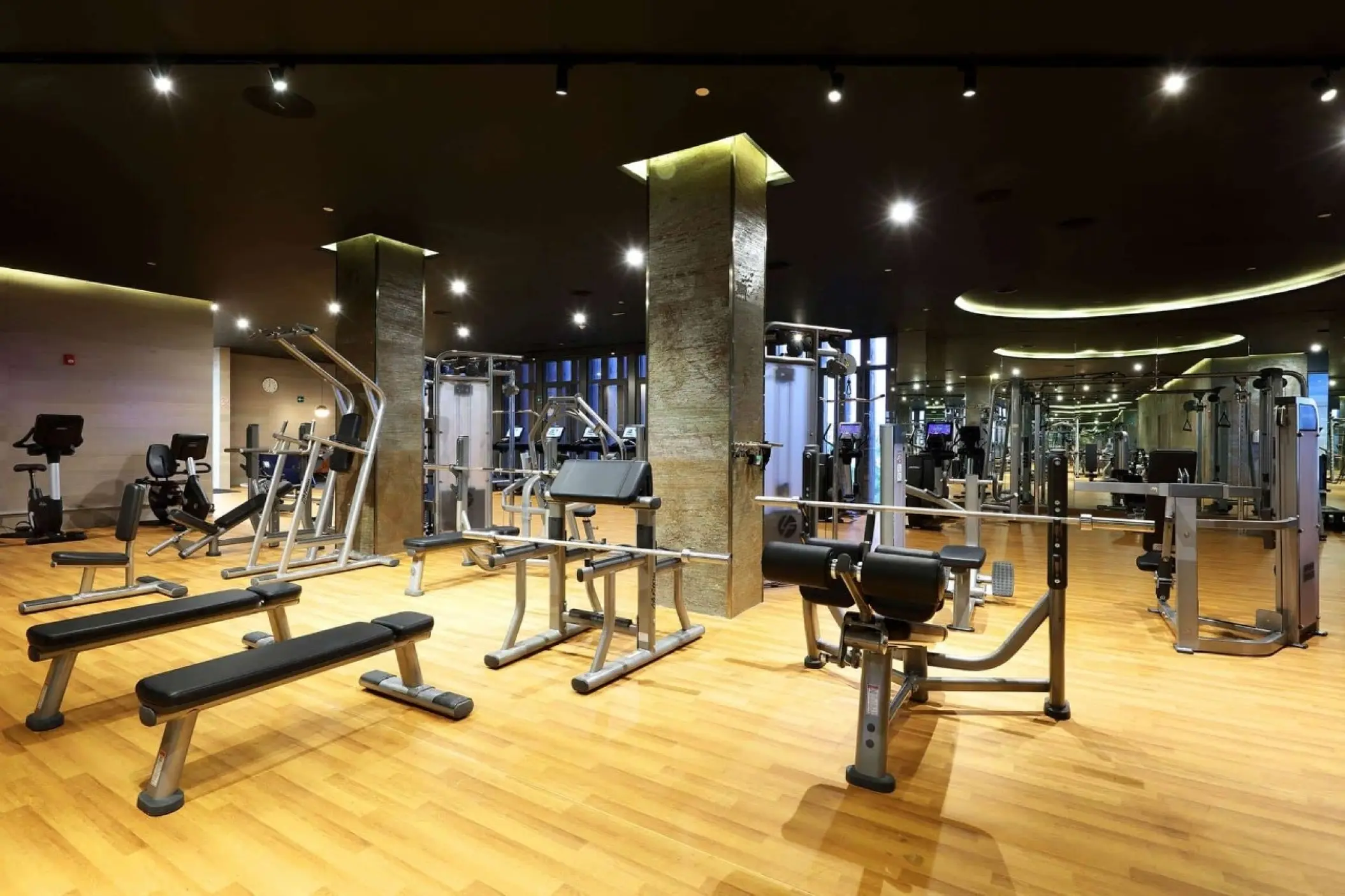 TRS Coral Hotel gym with weight benches and exercise machines, Cancun