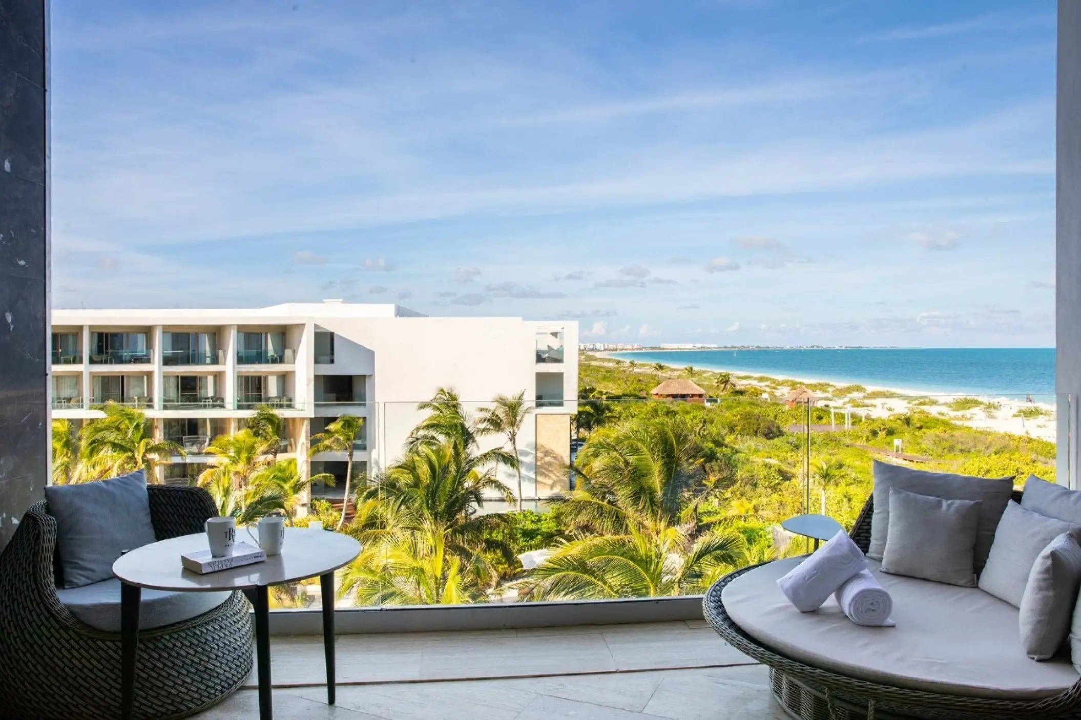 Junior suite beachfront balcony with daybed overlooking the coast at TRS Coral Hotel, Cancun