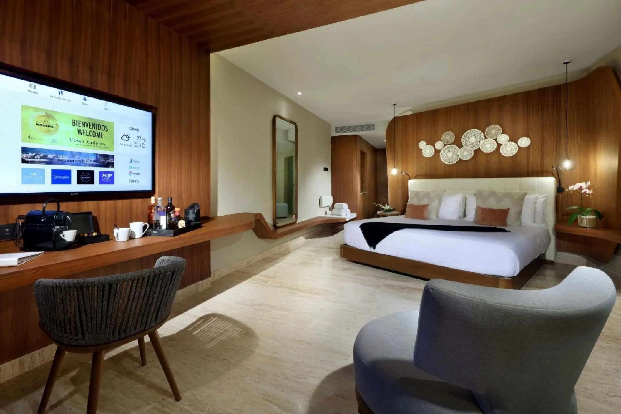Junior suite with wood-paneled walls and modern seating at TRS Coral Hotel, Cancun