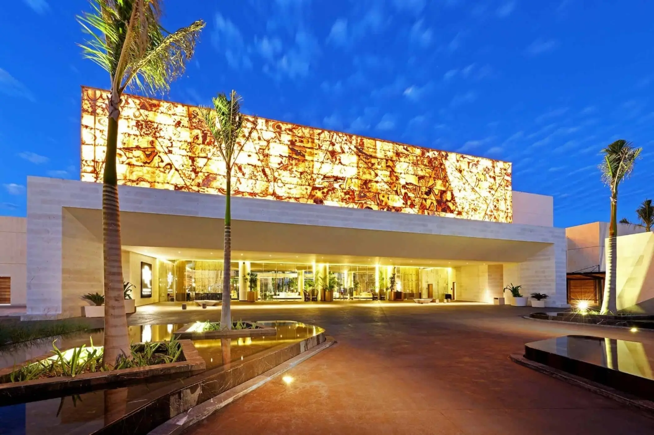 Illuminated main entrance and modern architectural facade at TRS Coral Hotel, Cancun