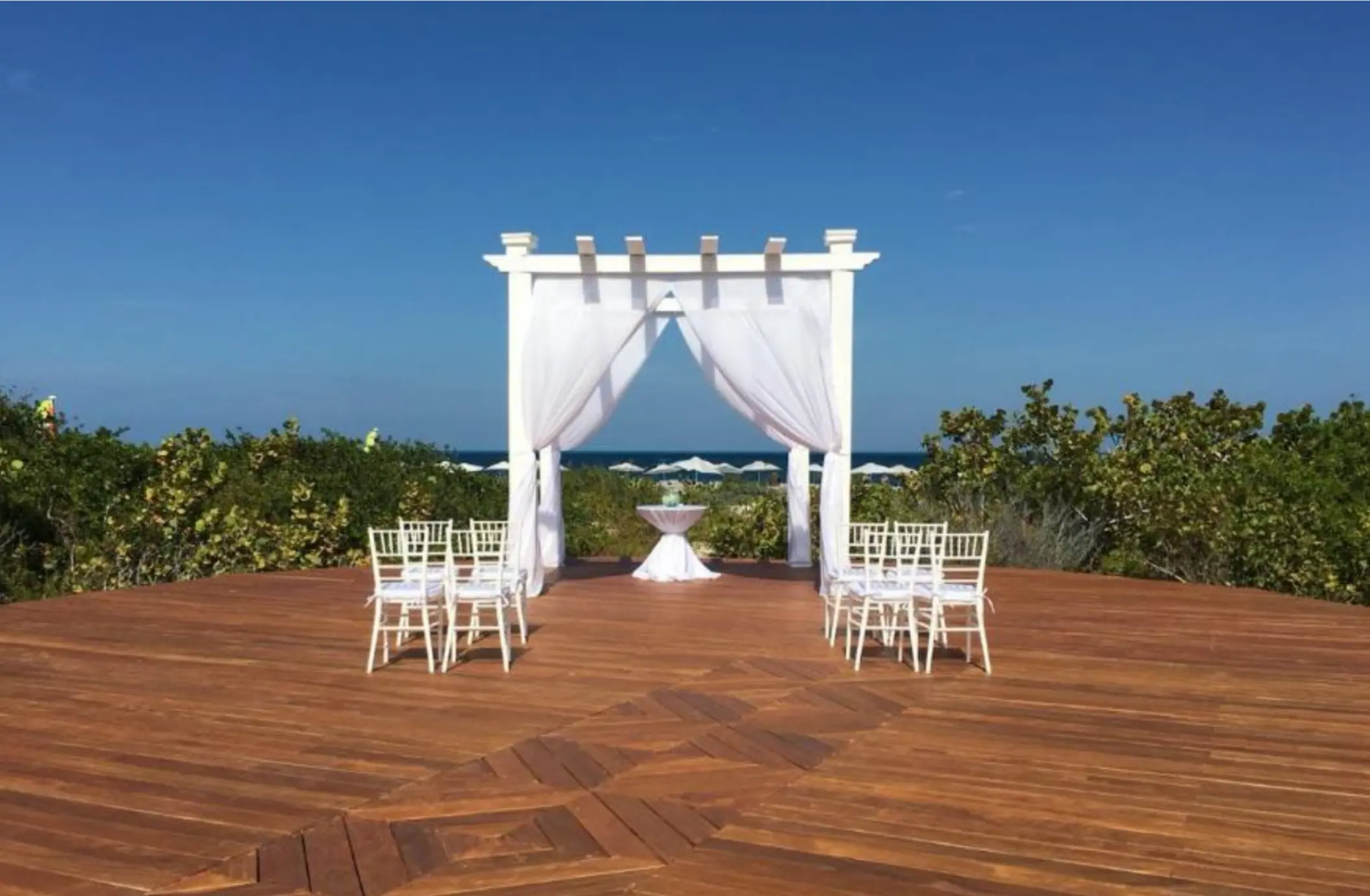 White wedding ceremony gazebo on a wooden sky deck at TRS Coral Hotel, Cancun