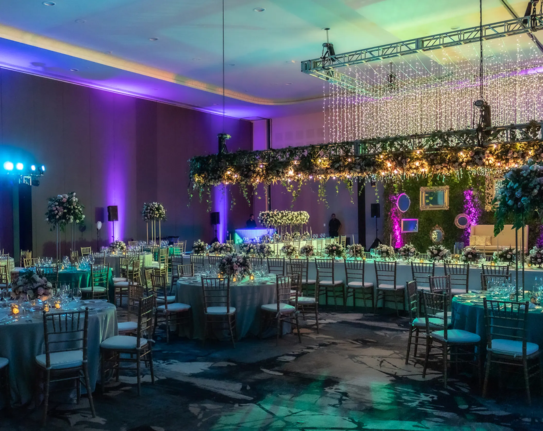 Ballroom wedding reception at UNICO 20°87°, Riviera Maya featuring purple and teal mood lighting and hanging greenery