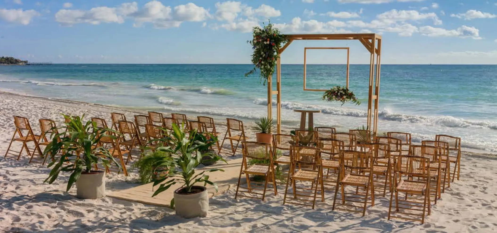 Beachfront wedding ceremony setup with a wooden arch at UNICO 20°87°, Riviera Maya
