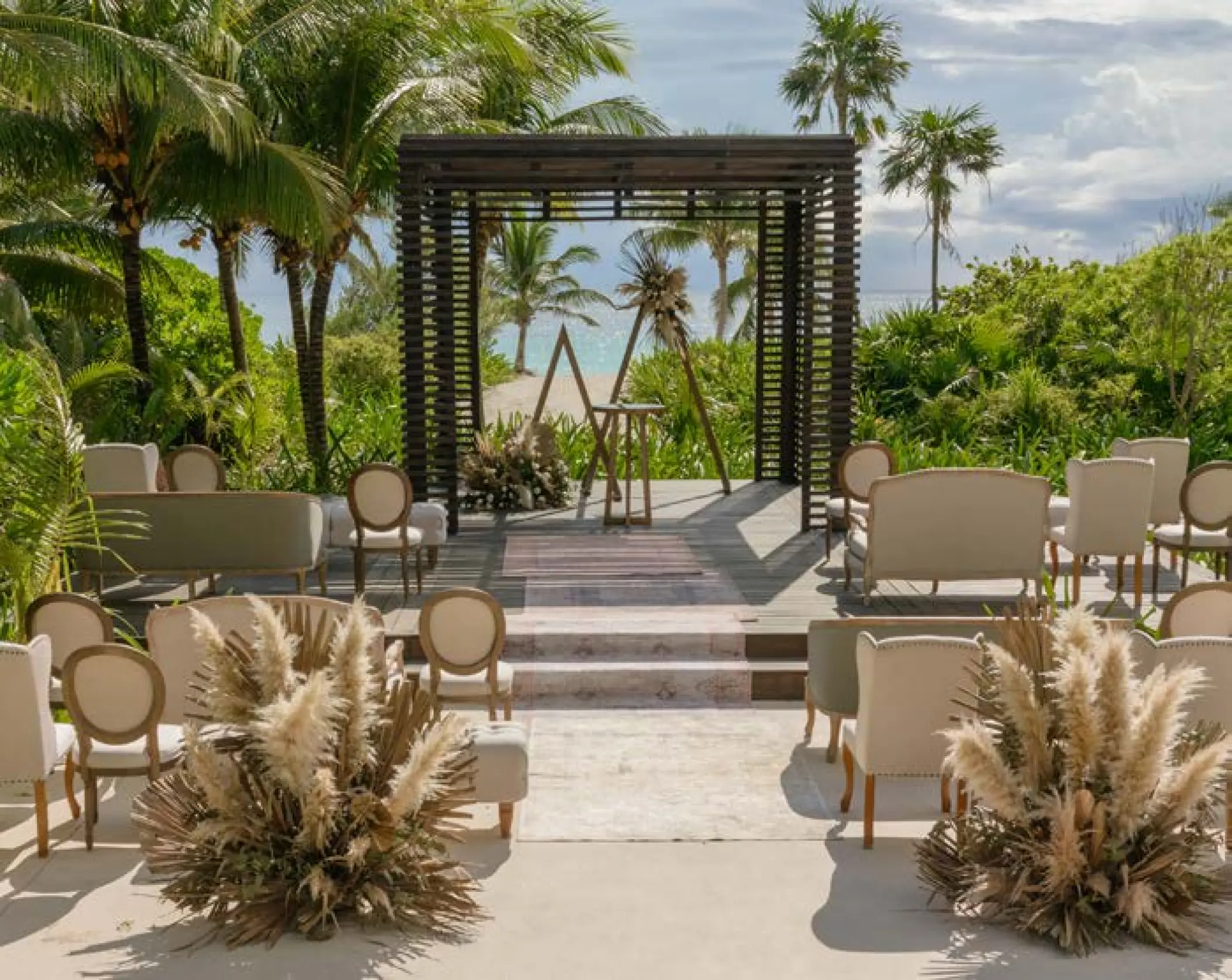 Wooden gazebo wedding ceremony with pampas grass and palm trees at UNICO 20°87°, Riviera Maya