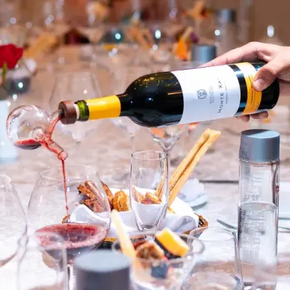 Red wine being poured at a wedding reception table at Valentin Imperial, Riviera Maya