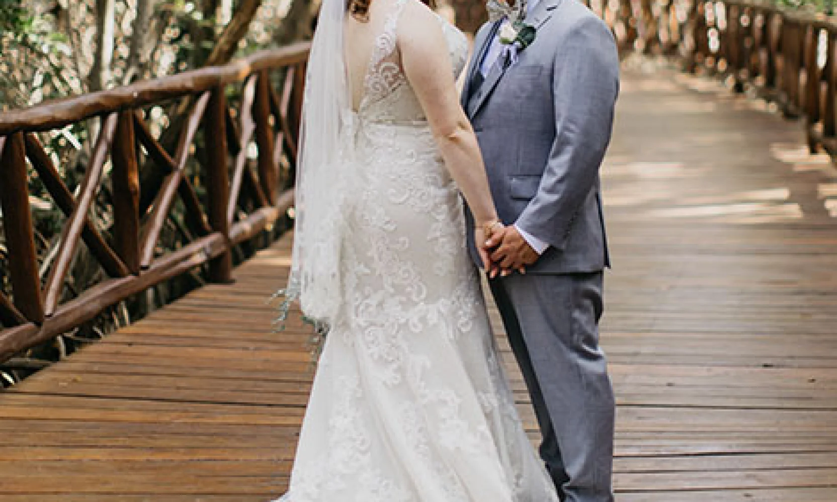 Couple posing for a shot on a wooden deck in the middle of the jungle