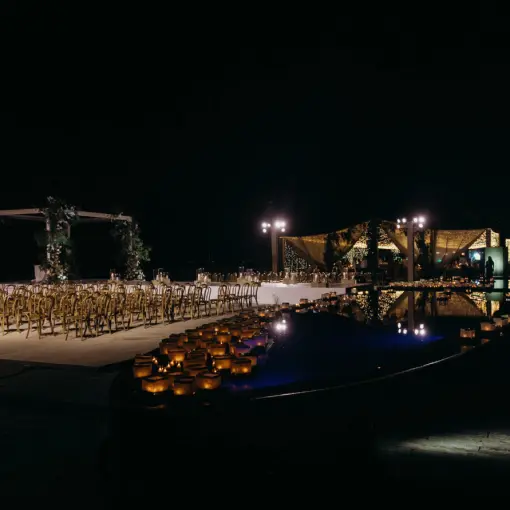 Nighttime beach ceremony setup with lantern-lined pool at Viceroy Los Cabos, Cabo San Lucas