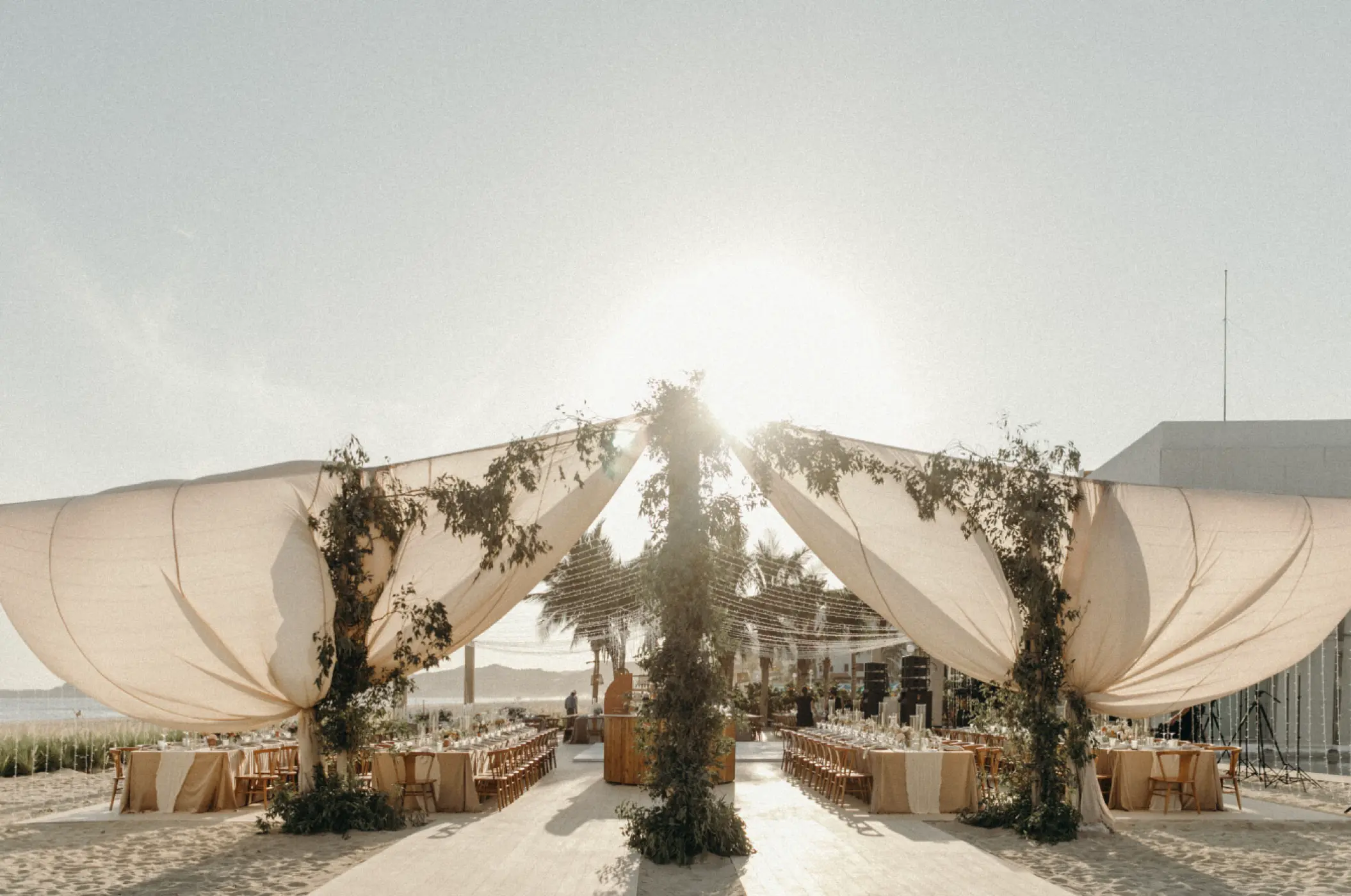 Beachfront wedding reception setup under draped white sails at Viceroy Los Cabos, Cabo San Lucas