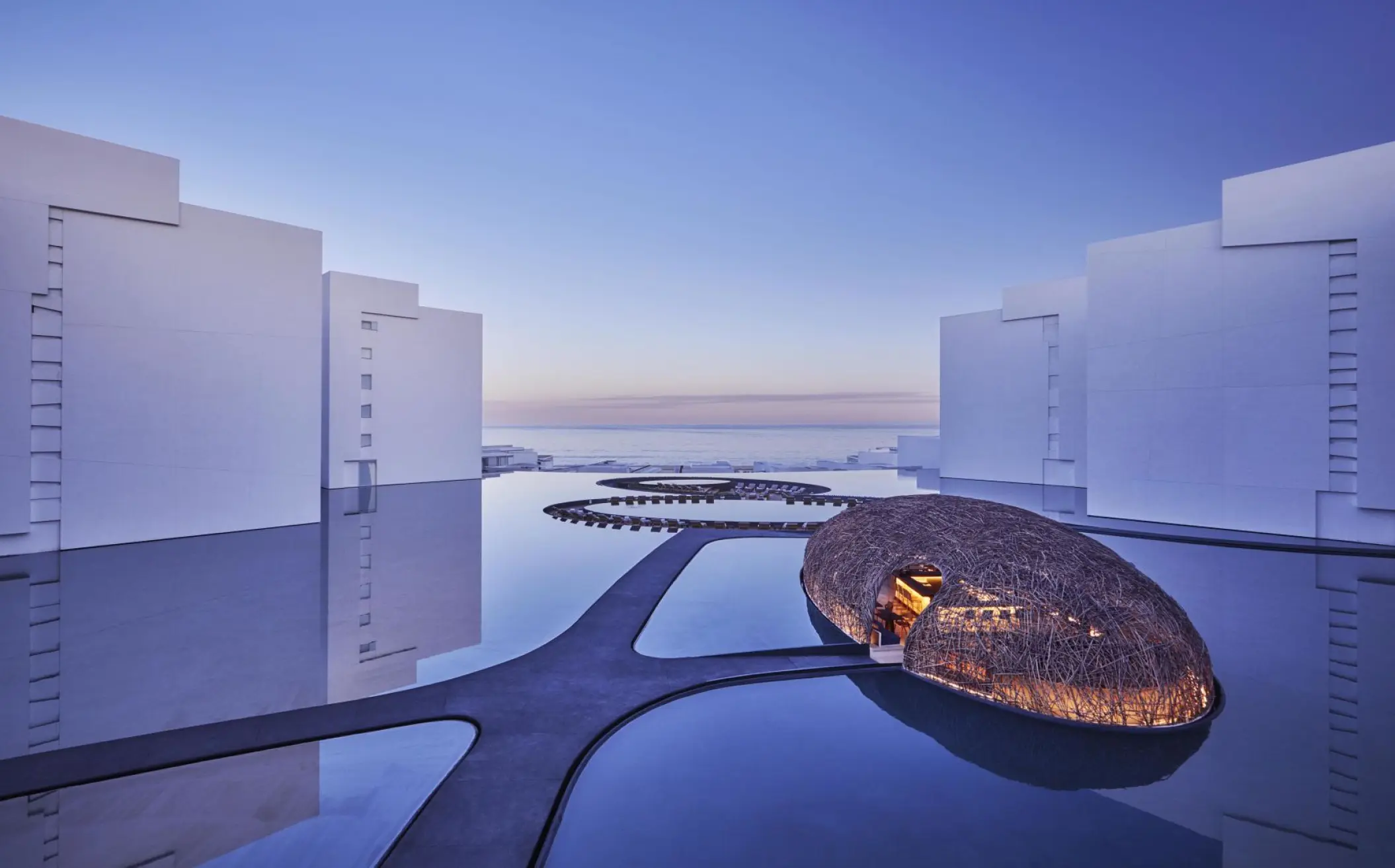 Minimalist courtyard pools and Nido structure at Viceroy Los Cabos at dusk, Cabo San Lucas