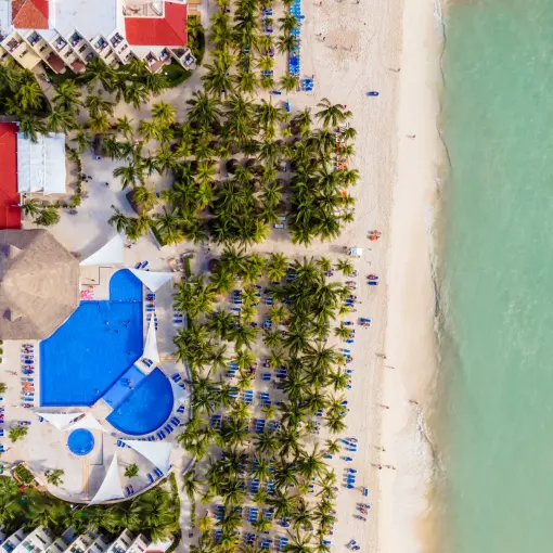 Aerial view of Viva Maya by Wyndham pools, palm trees, and white sand beach, Playa Del Carmen