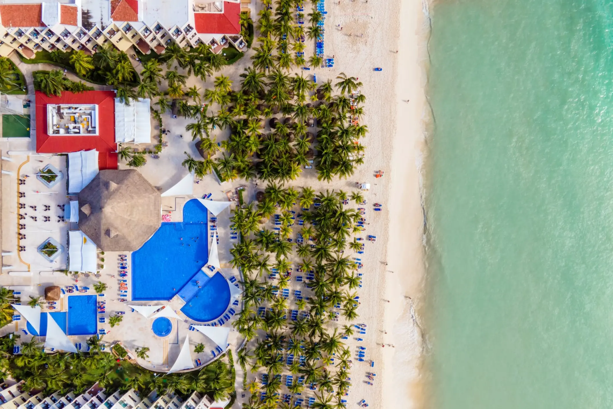 Aerial view of Viva Maya by Wyndham pools, palm trees, and white sand beach, Playa Del Carmen