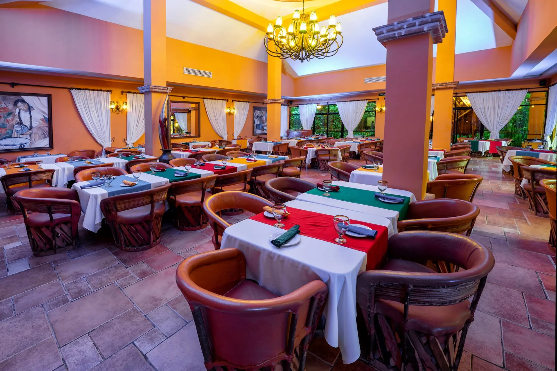 Indoor restaurant with colorful table linens and chandelier at Viva Maya by Wyndham, Playa Del Carmen