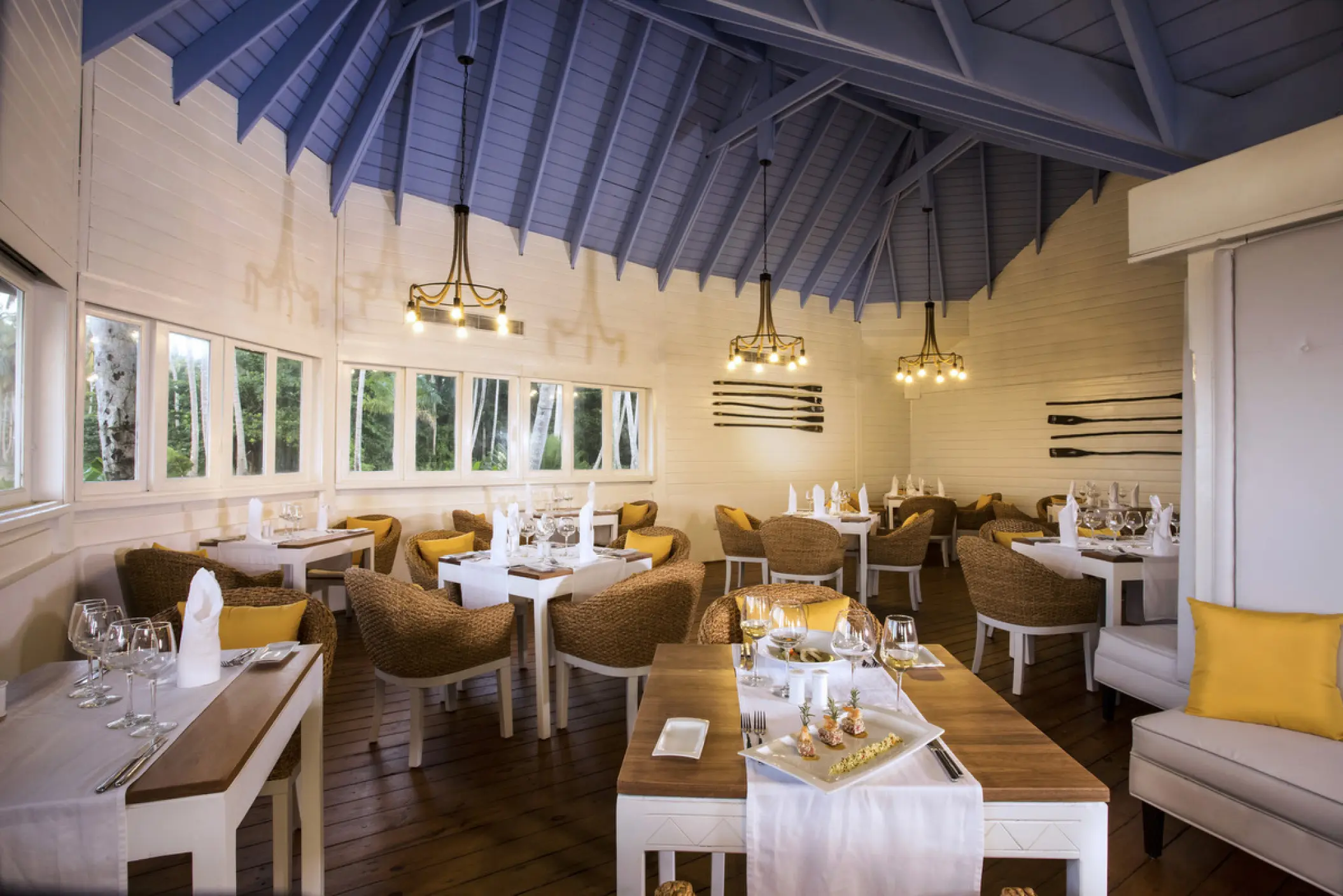 Indoor restaurant with vaulted blue ceilings and wicker chairs at Viva V Samana, Samana