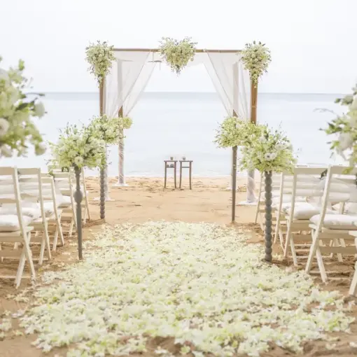 Beachfront wedding ceremony with white flowers and chairs at Viva V Samana, Samana