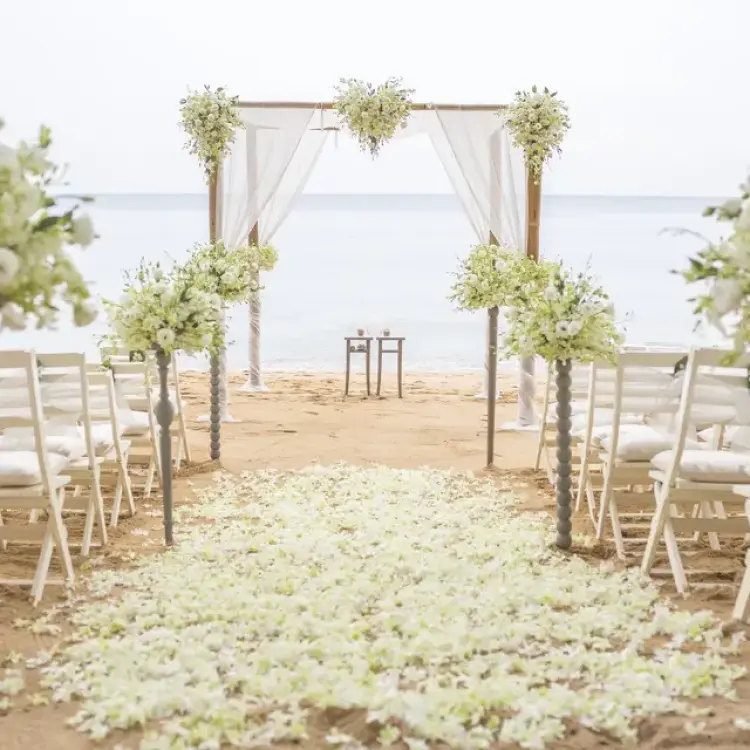Beachfront wedding ceremony with white flowers and chairs at Viva V Samana, Samana