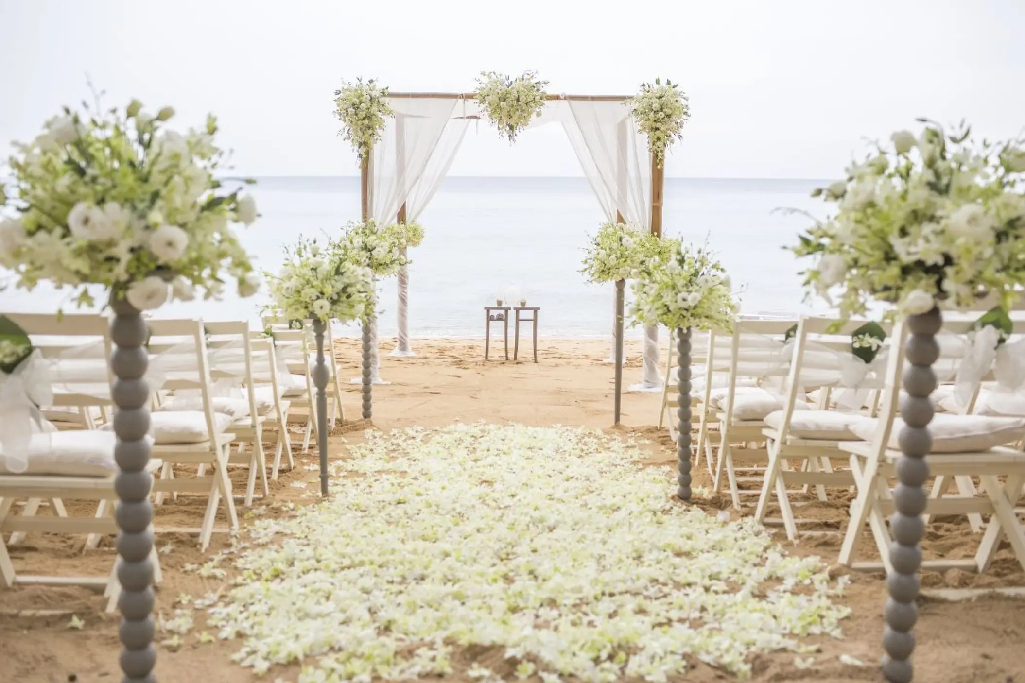 Beachfront wedding ceremony with white floral arch and petal aisle at Viva V Samana, Samana