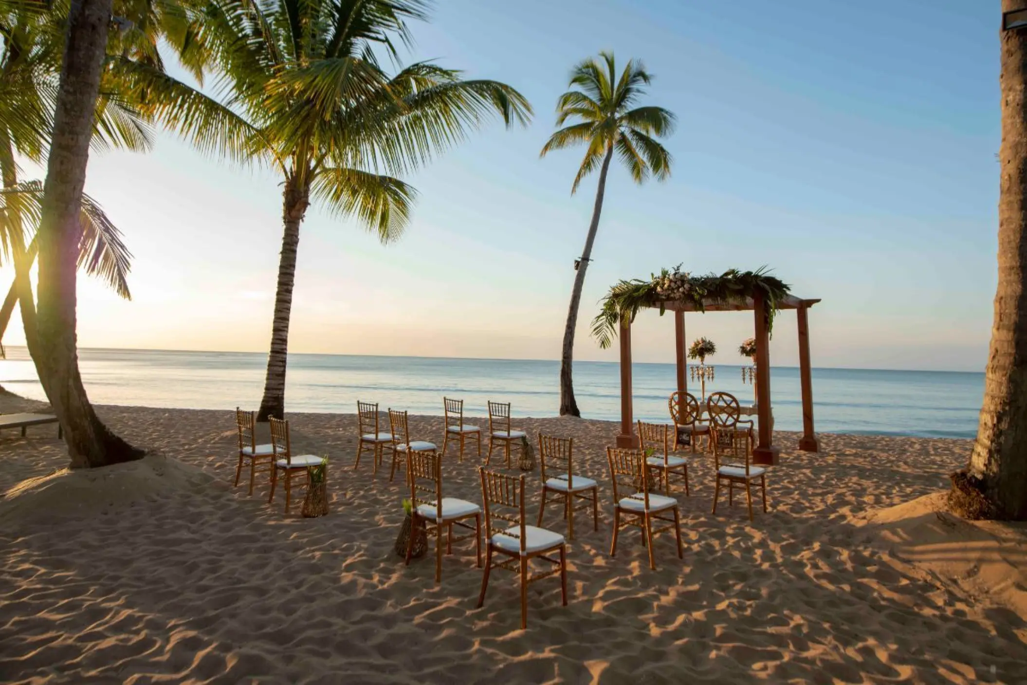 Beachfront wedding ceremony setup under palm trees at Viva V Samana, Samana