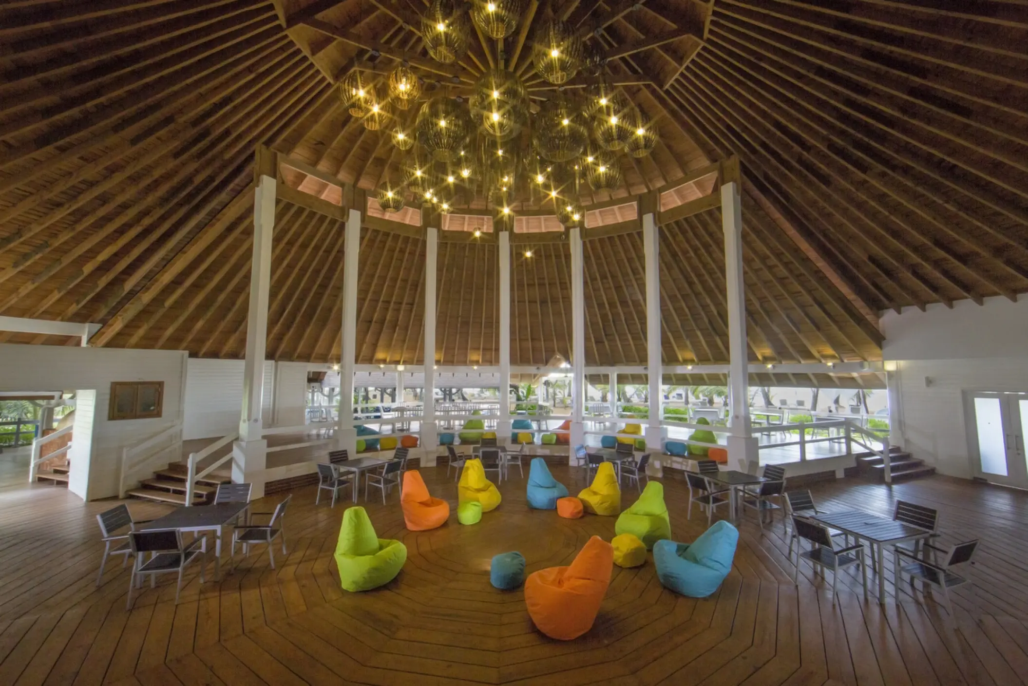 Colorful beanbag chairs under a high wooden thatched ceiling at Viva V Samana, Samana