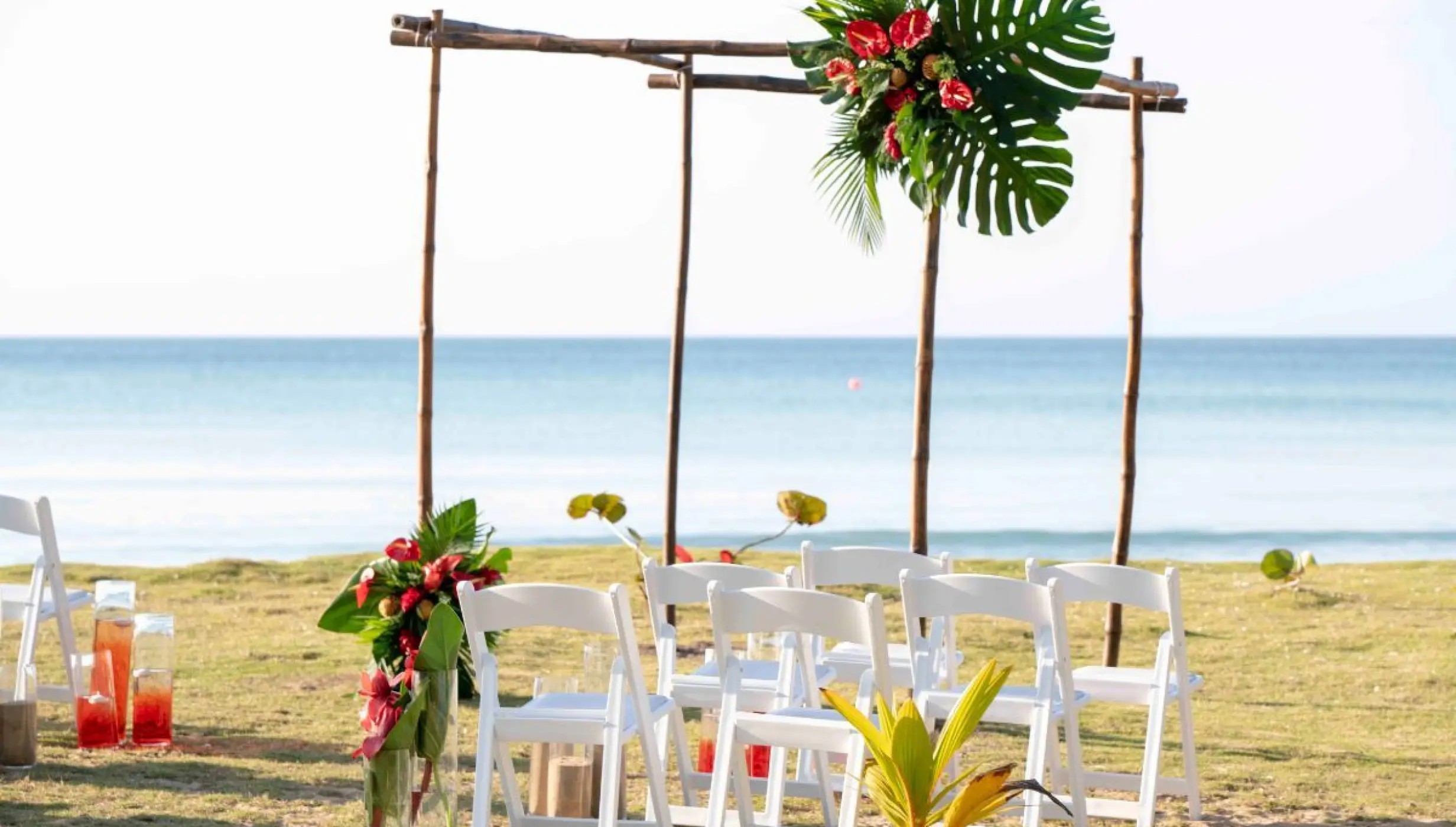 Wooden beach ceremony arch with tropical greenery at Viva V Samana, Samana