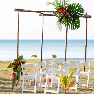 Wooden beach ceremony arch with tropical greenery at Viva V Samana, Samana