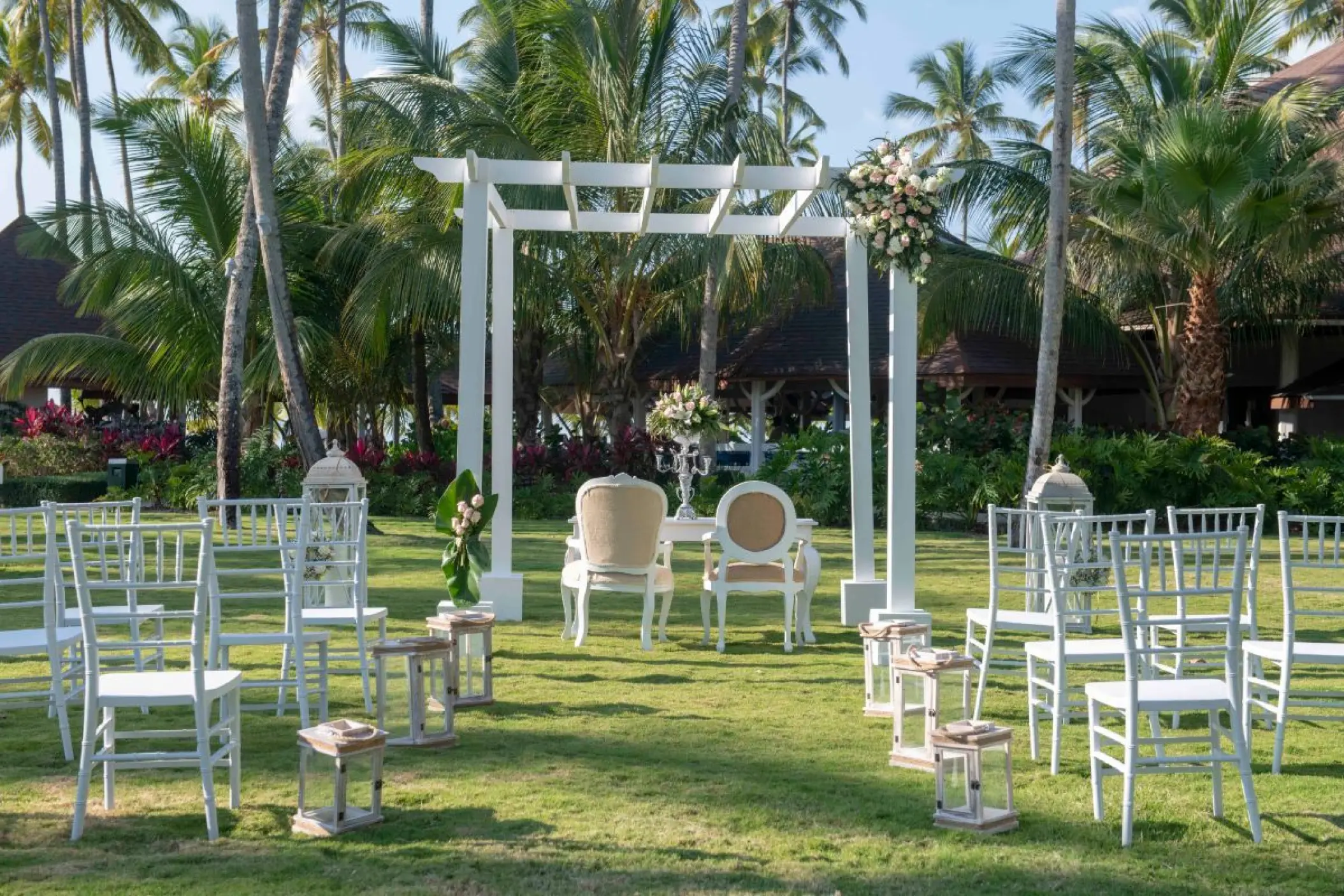 Garden wedding ceremony under a white pergola with tiffany chairs at Viva V Samana, Samana
