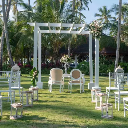 Garden wedding ceremony under a white pergola with tiffany chairs at Viva V Samana, Samana
