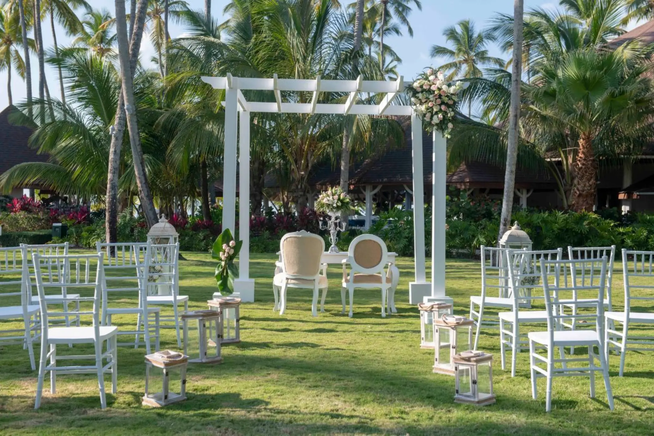 Garden wedding ceremony setup with a white pergola and chairs at Viva V Samana, Samana