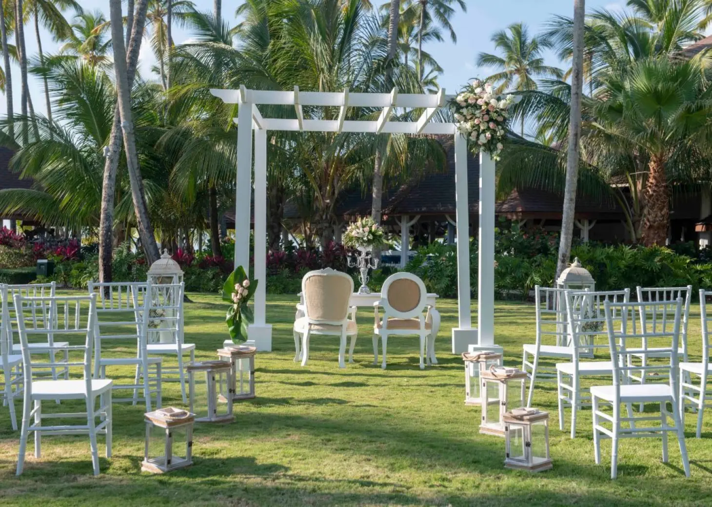Garden wedding ceremony setup with a white pergola and chairs at Viva V Samana, Samana