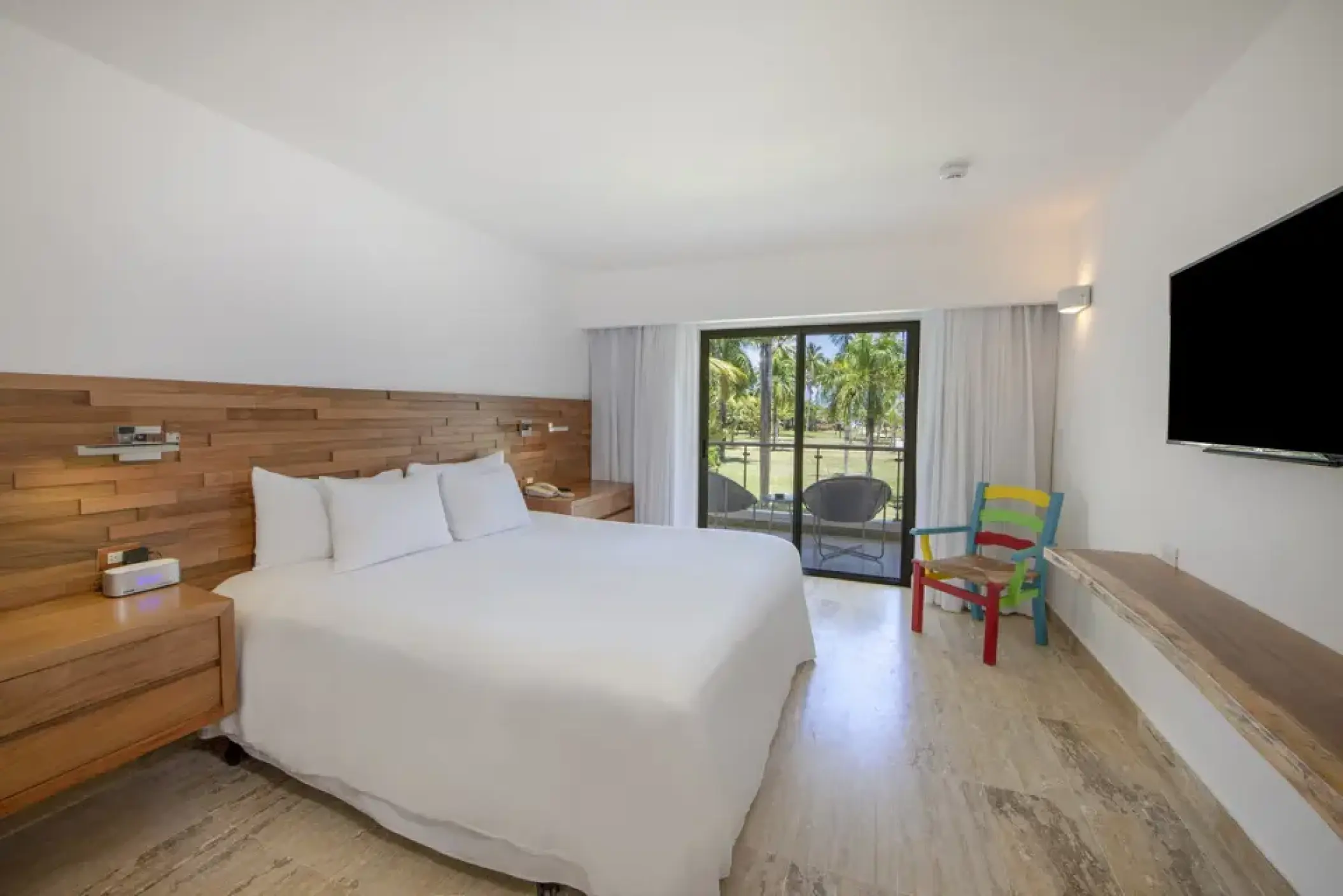 Modern guest room with wood paneling and private balcony at Viva V Samana, Samana