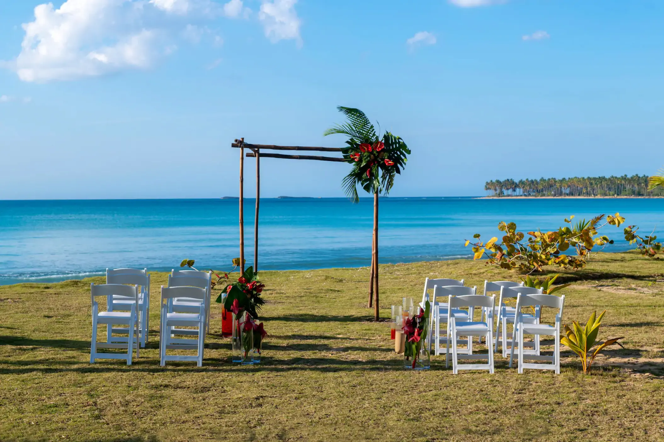 Waterfront wedding ceremony with wooden arch and white chairs at Viva V Samana, Samana