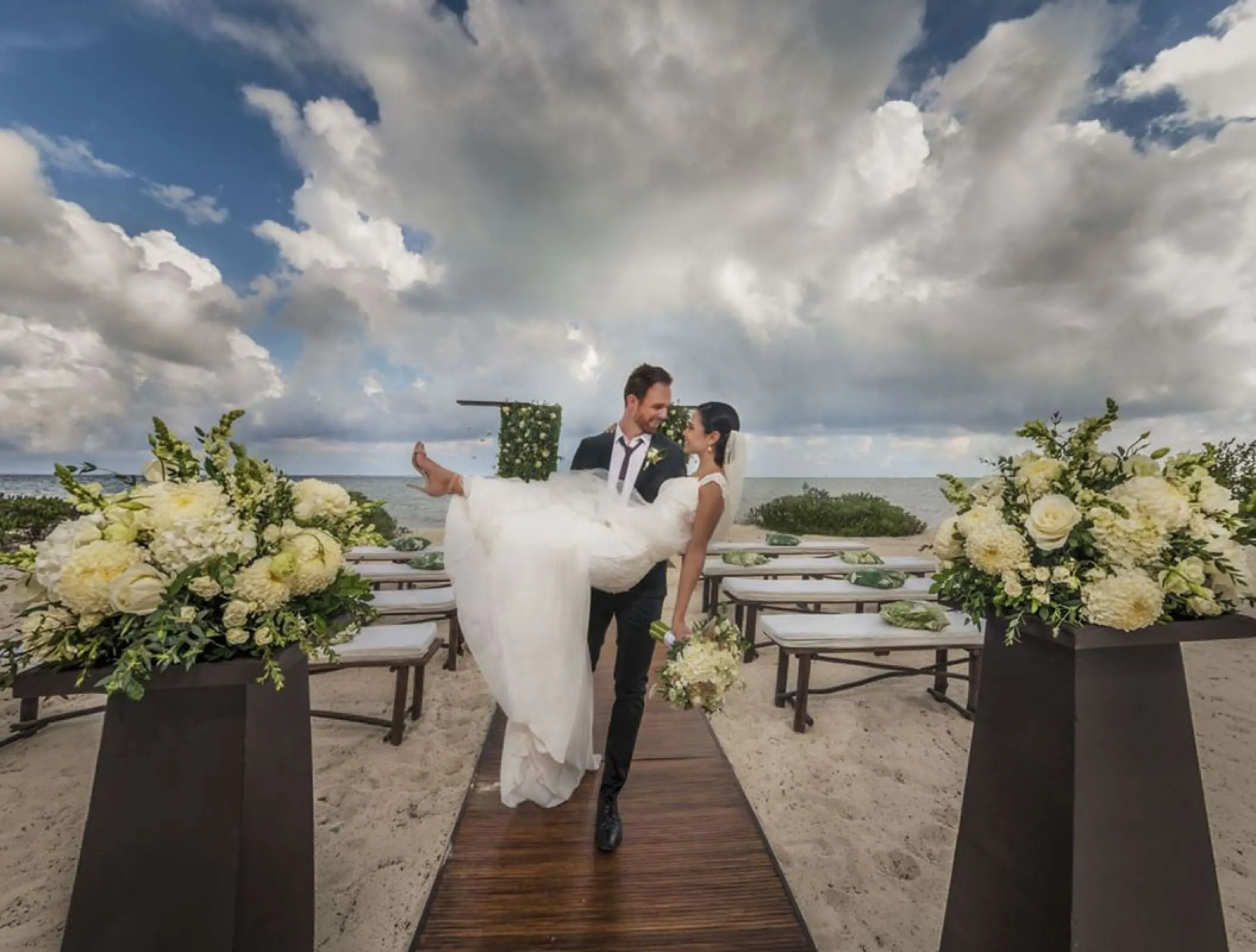 Groom carrying bride down the aisle at Haven Riviera Cancun, Riviera Maya