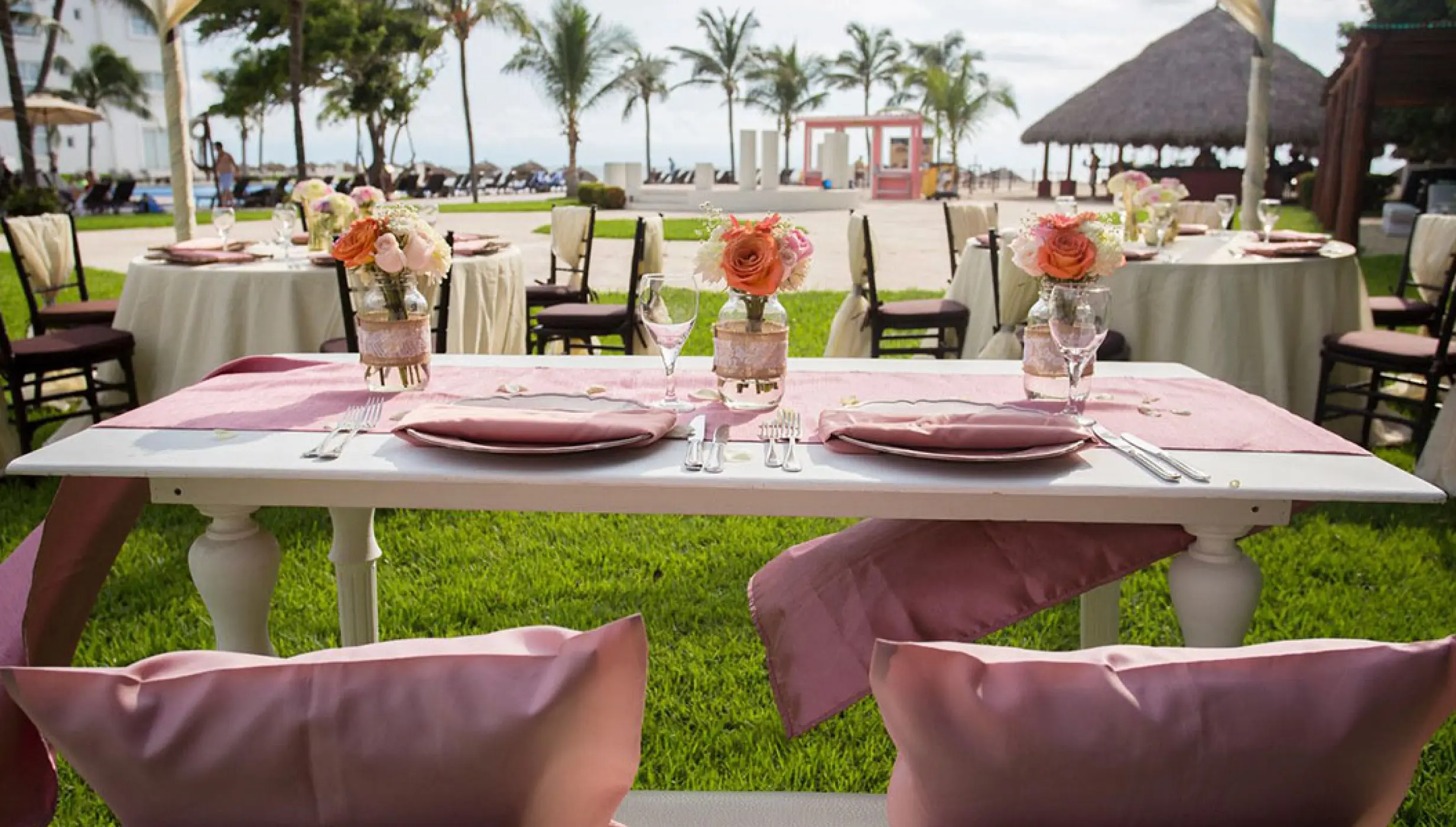 Garden wedding reception with pink floral centerpieces at Wyndham Alltra Riviera Nayarit, Puerto Vallarta