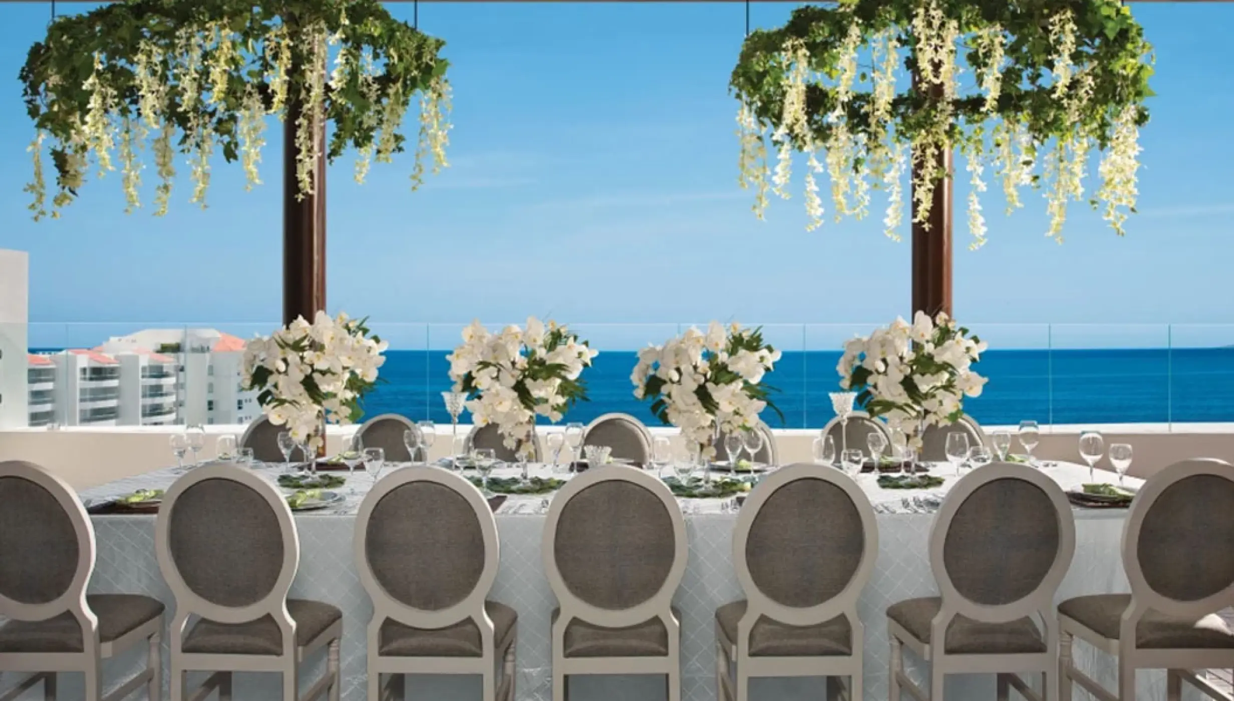 Terrace wedding reception with floral centerpieces overlooking the ocean at Wyndham Alltra Riviera Nayarit, Puerto Vallarta