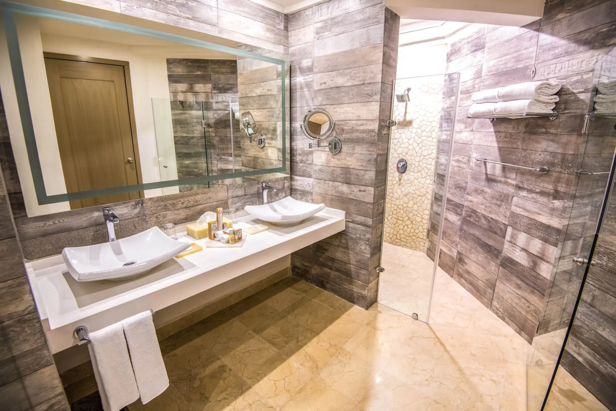 Modern suite bathroom with double vessel sinks and walk-in shower at Wyndham Alltra Playa del Carmen