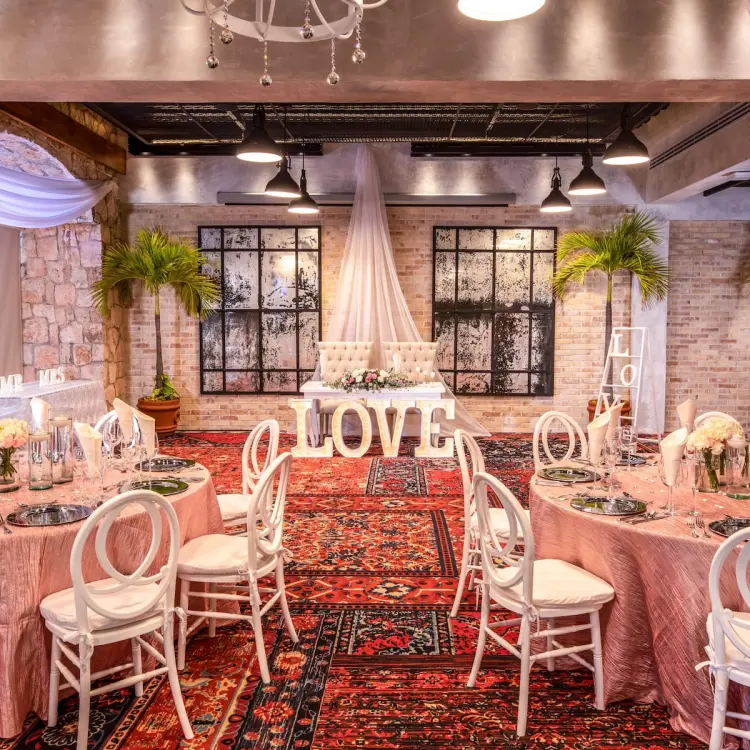 Indoor wedding reception at Wyndham Alltra Playa del Carmen with pink table linens and white LOVE letters