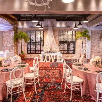 Indoor wedding reception at Wyndham Alltra Playa del Carmen with pink table linens and white LOVE letters