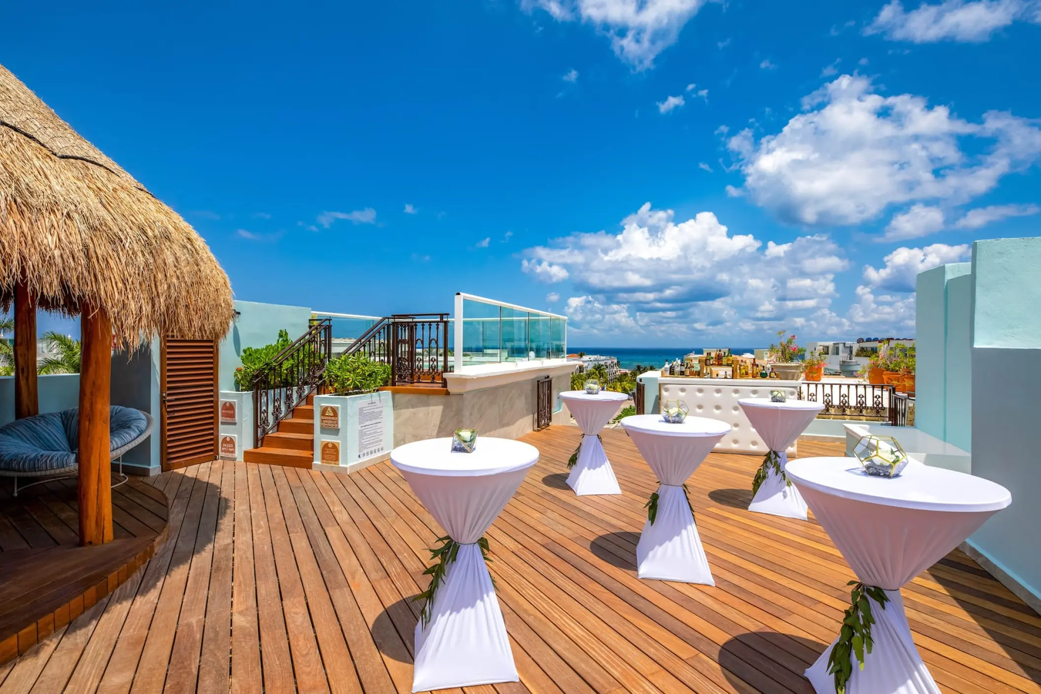Terrace wedding reception with cocktail tables and a thatched gazebo at Wyndham Alltra Playa del Carmen
