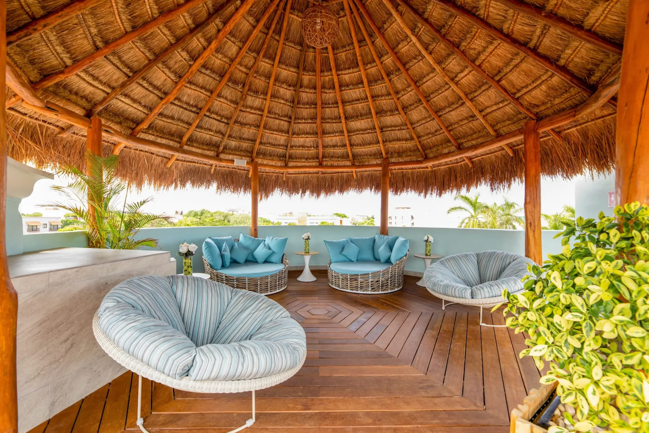 Terrace lounge area under a thatched palapa roof at Wyndham Alltra Playa del Carmen