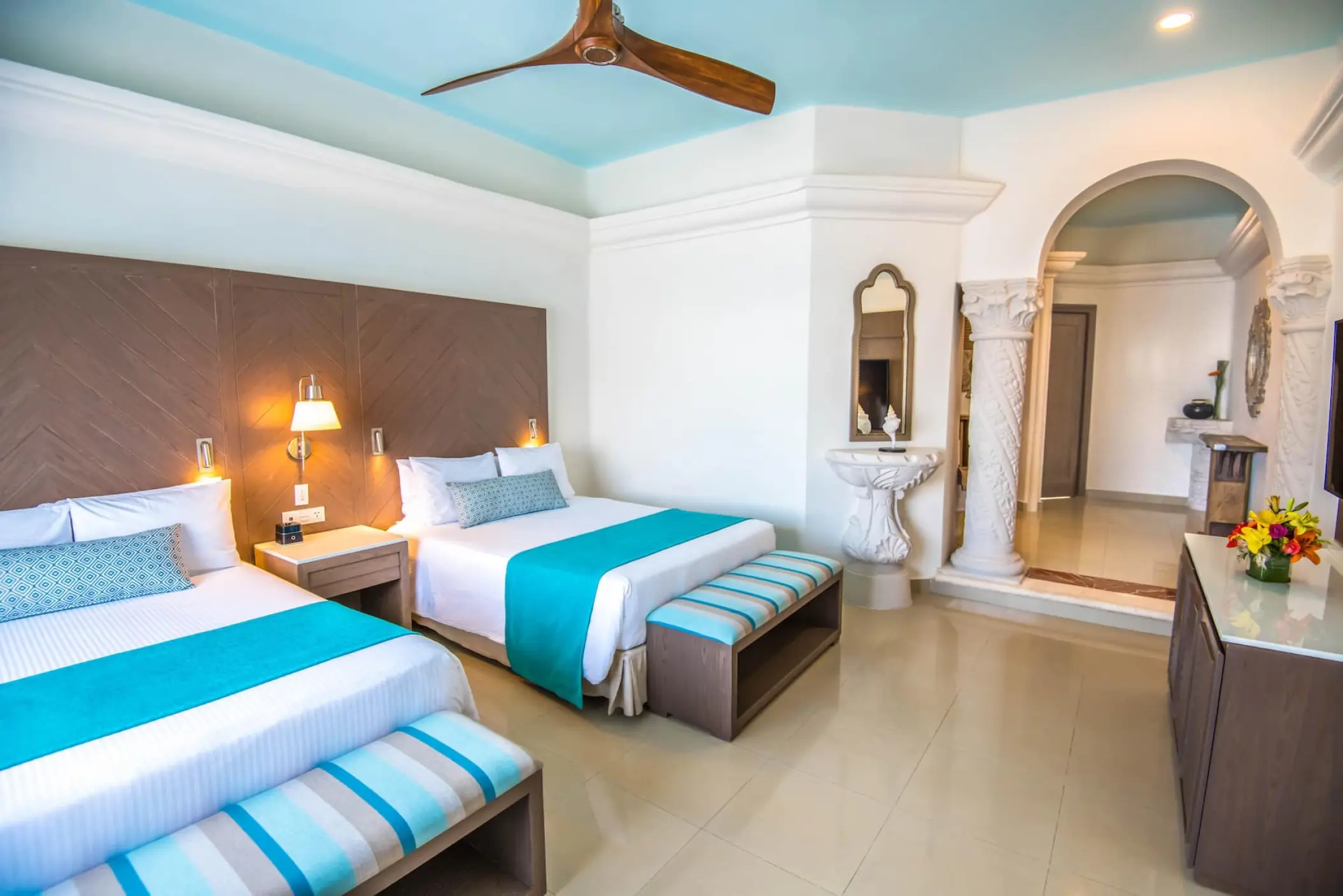 Two-bed guest room with teal accents and archway at Wyndham Alltra Playa del Carmen
