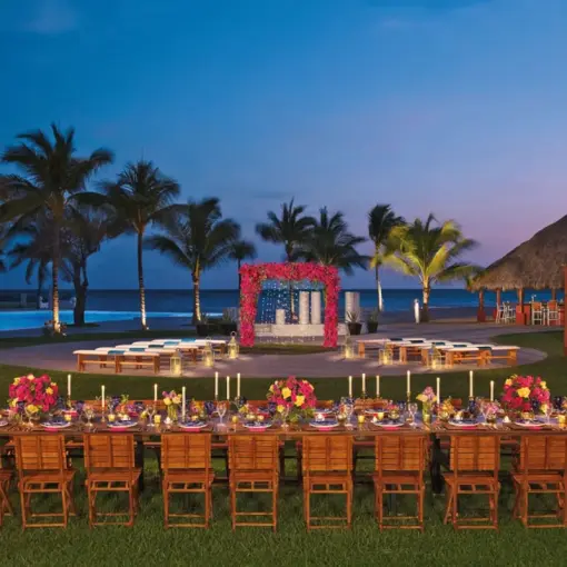 Outdoor wedding reception and ceremony setup with pink floral arch at Wyndham Alltra Riviera Nayarit, Puerto Vallarta