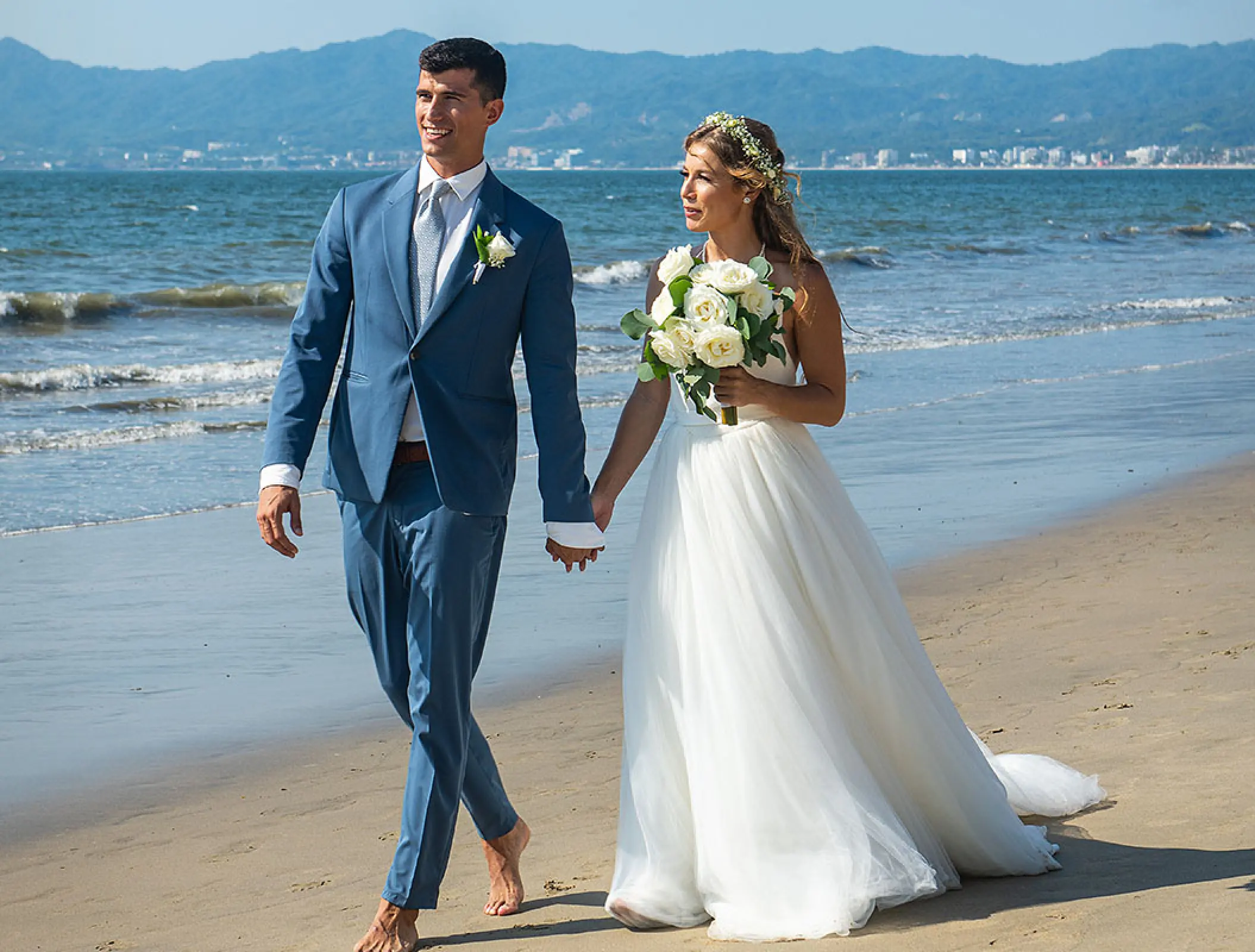 Bride and groom walking barefoot on the beach at Wyndham Alltra Riviera Nayarit, Puerto Vallarta