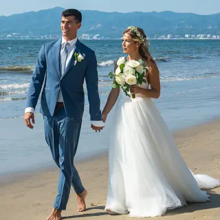 Bride and groom walking barefoot on the beach at Wyndham Alltra Riviera Nayarit, Puerto Vallarta