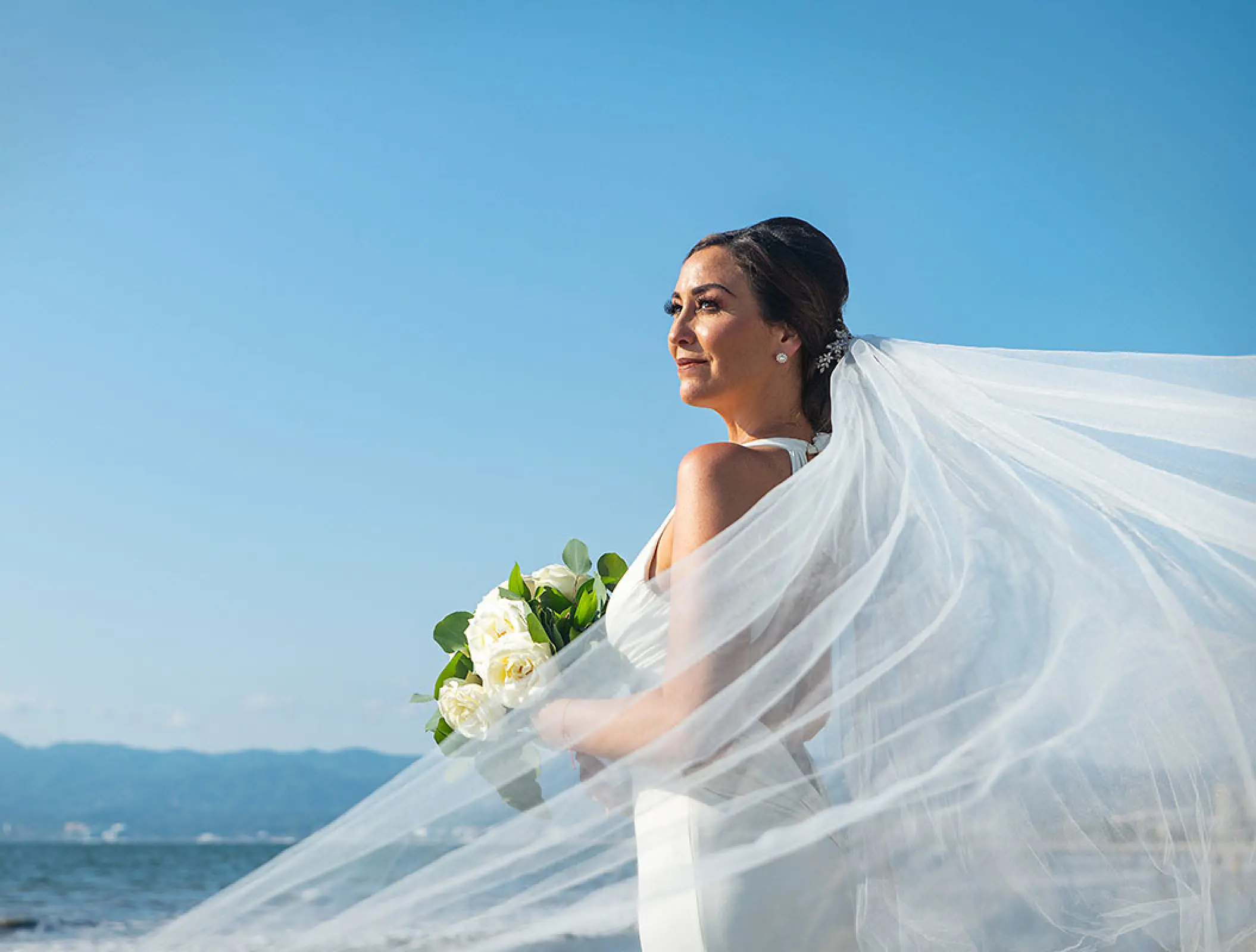 Bride with a flowing veil and white bouquet at Wyndham Alltra Riviera Nayarit, Puerto Vallarta
