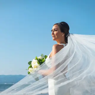 Bride with flowing veil and bouquet on the beach at Wyndham Alltra Riviera Nayarit, Puerto Vallarta