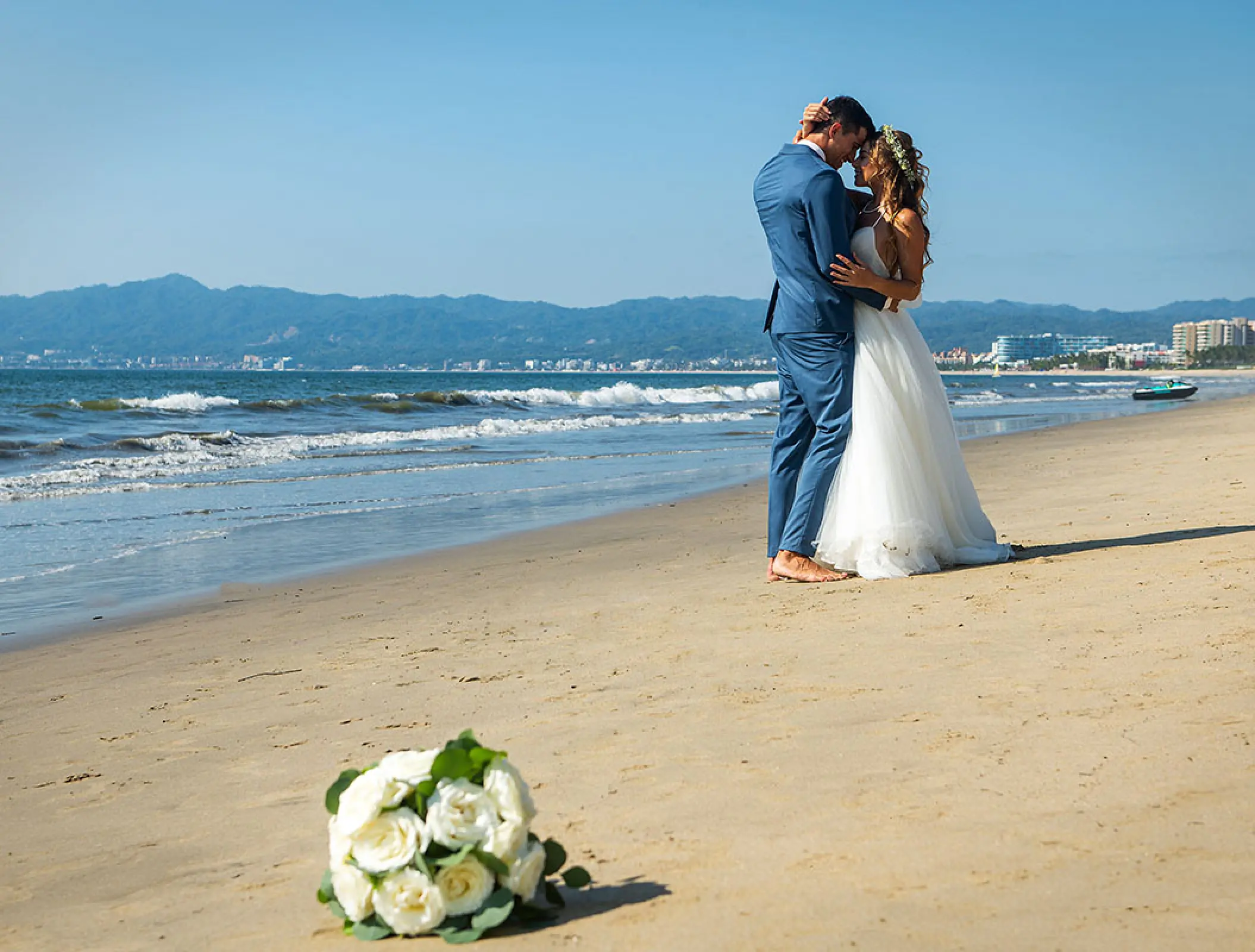 Bride and groom hugging on the beach at Wyndham Alltra Riviera Nayarit, Puerto Vallarta