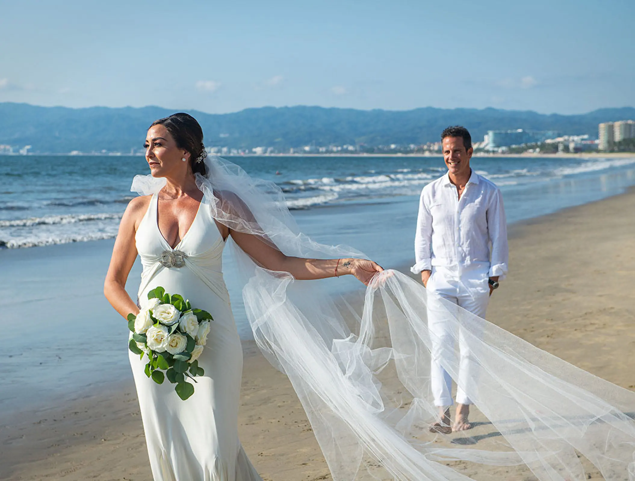 Bride and groom walking on the beach at Wyndham Alltra Riviera Nayarit, Puerto Vallarta