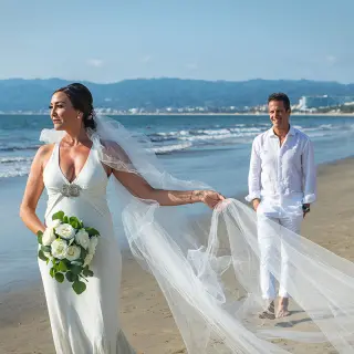 Bride and groom walking on the beach at Wyndham Alltra Riviera Nayarit, Puerto Vallarta